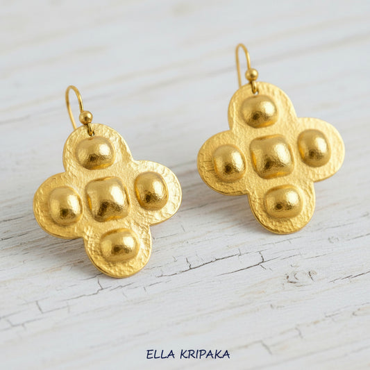 Hammered 24k Gold textured Byzantine cross earrings with convex squares and ovals on a white rustic wooden background, and with 'Ella Kripaka' branding
