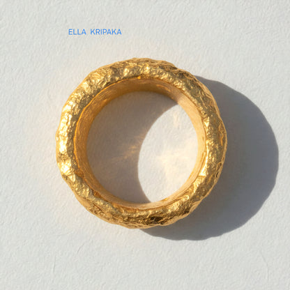 Organic hammered 24k Gold 9999 gold ring signet with thick edges and with textured surface on a white paper background, branded 'Ella Kripaka'
