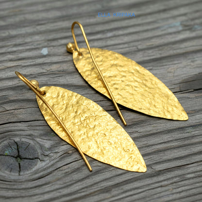 Hammered 24k 9999 Gold Byzantine leaf earrings on a old wooden background with 'Ella Kripaka' branding
