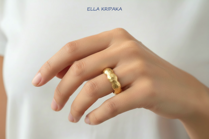 Organic hammered 24k 9999 Gold ring with wavy thick edges worn on person's finger and on a white background, artist-jeweler's name 'Ella Kripaka' is written in picture