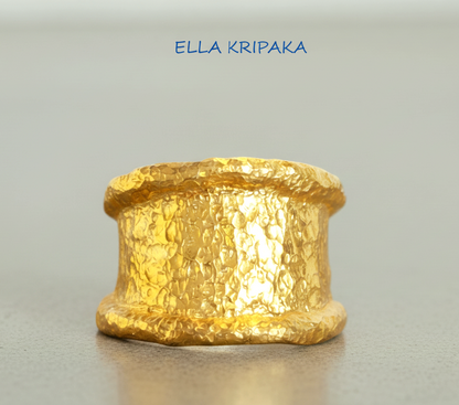 Organic hammered 24k 9999 gold ring signet with uneven thick edges on grey surface, artist-jeweler's name 'Ella Kripaka' is written in picture