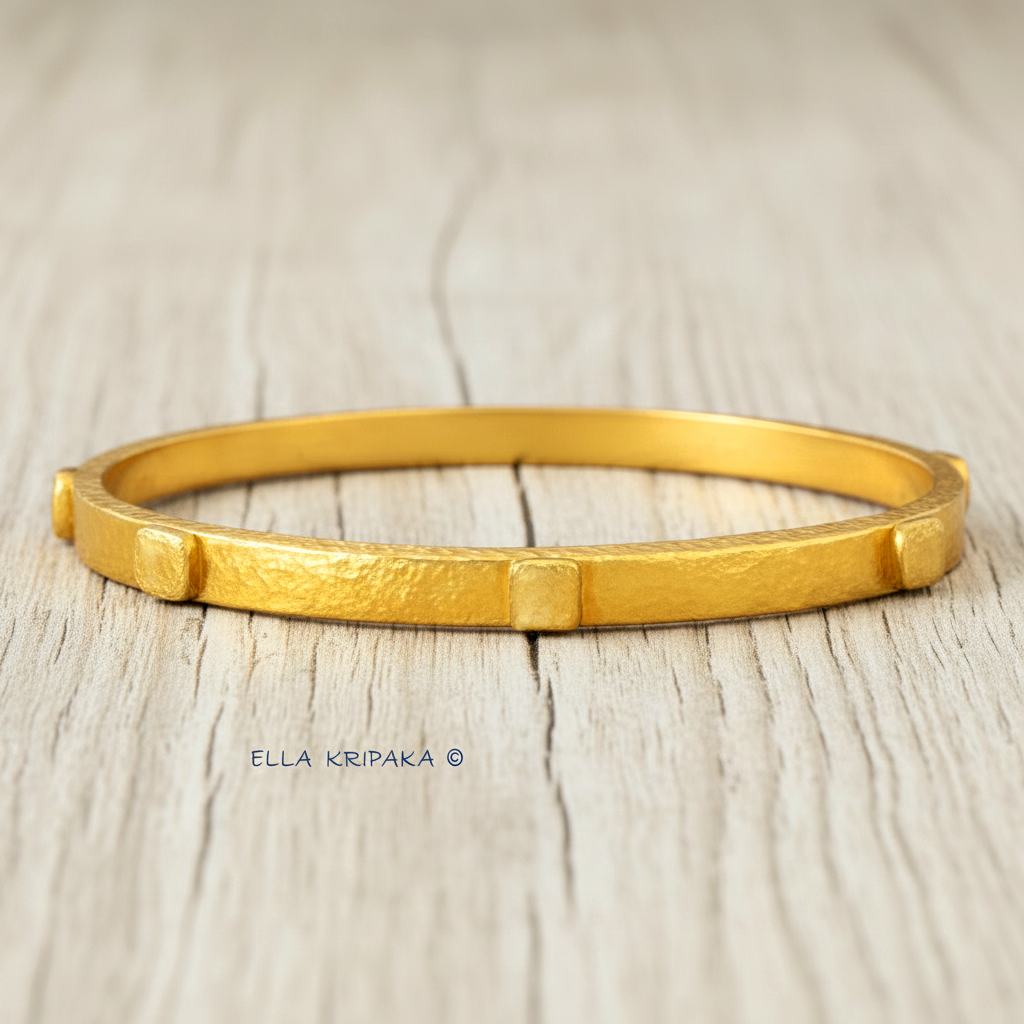 24k gold hammered bangle textured bracelet with thick squares on white rustic wooden surface, artist 'Ella Kripaka' branding