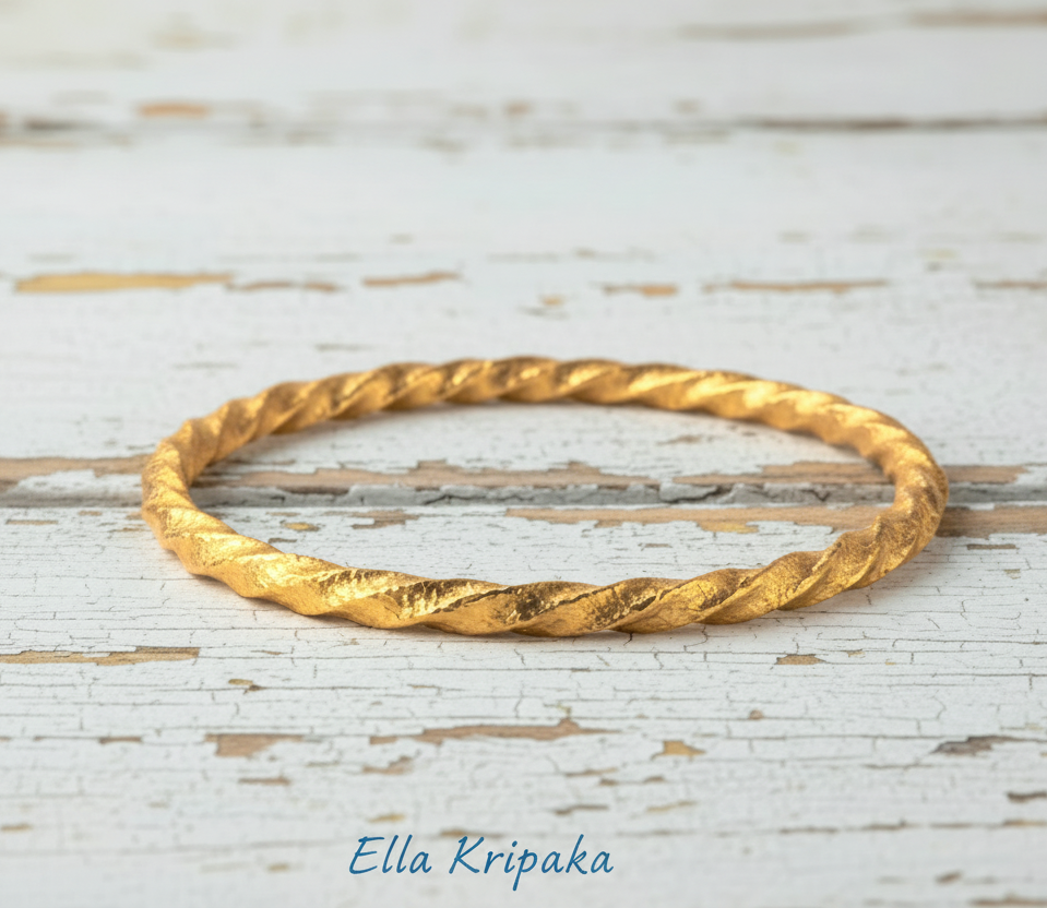 Twisted Viking Hammered 24k 9999 Gold bangle bracelet on white wooden surface, artist's name 'Ella Kripaka' branding