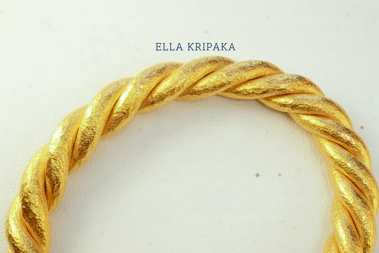 Twisted Viking Hammered 24k 9999 gold bracelet thick cuff on a white background, branding artist-jeweler name 'Ella Kripaka'