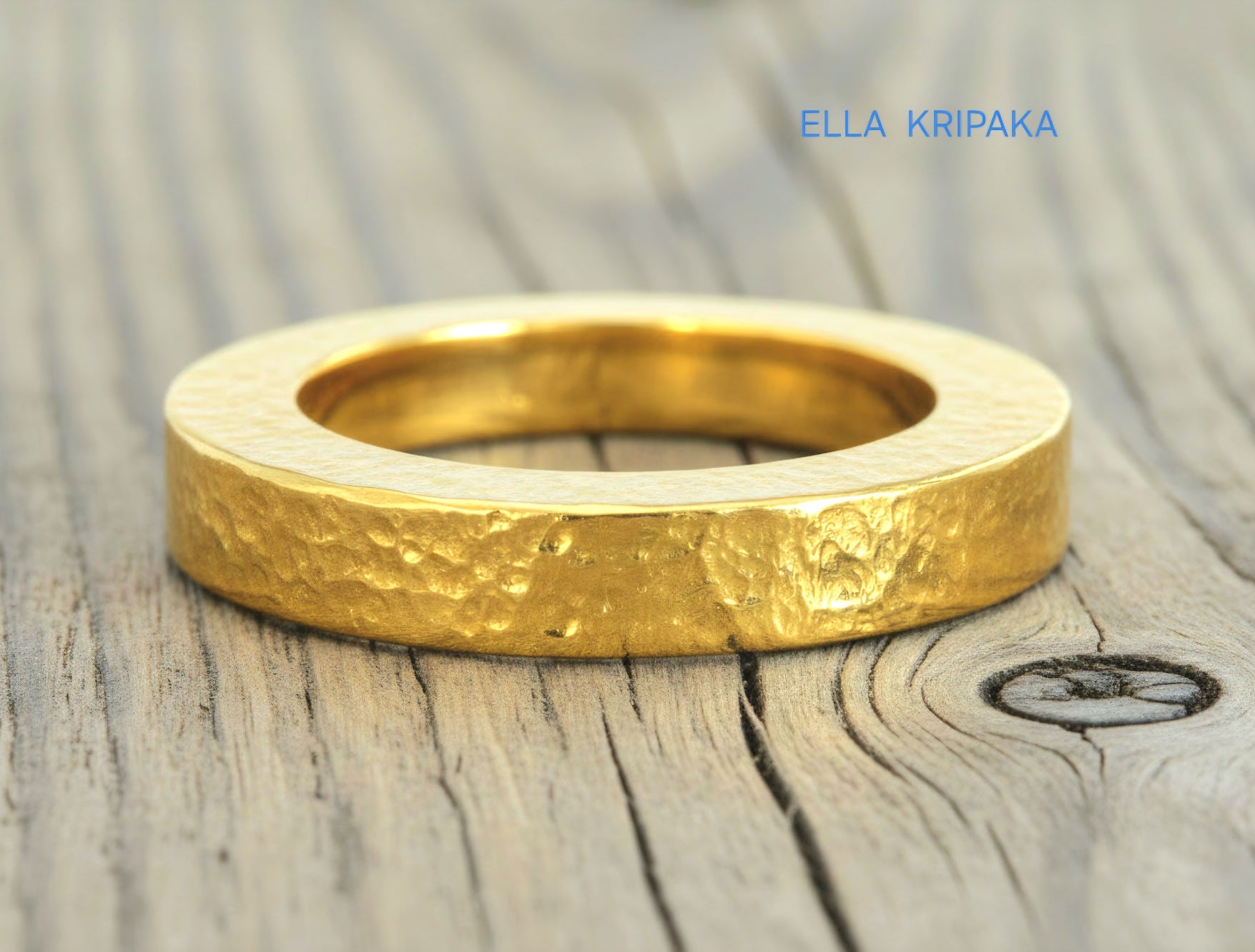 Hammered 24k Gold 9999 gold Ancient Rome  thick ring with textured forged gold on a grey old wooden background, branded artist-jeweler's name 'Ella Kripaka'