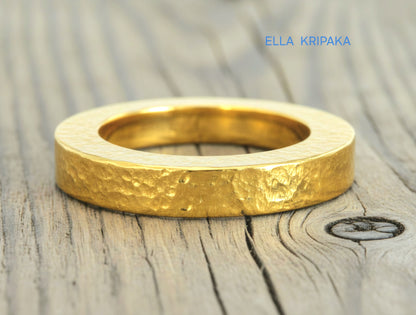 Hammered 24k Gold 9999 gold Ancient Rome  thick ring with textured forged gold on a grey old wooden background, branded artist-jeweler's name 'Ella Kripaka'