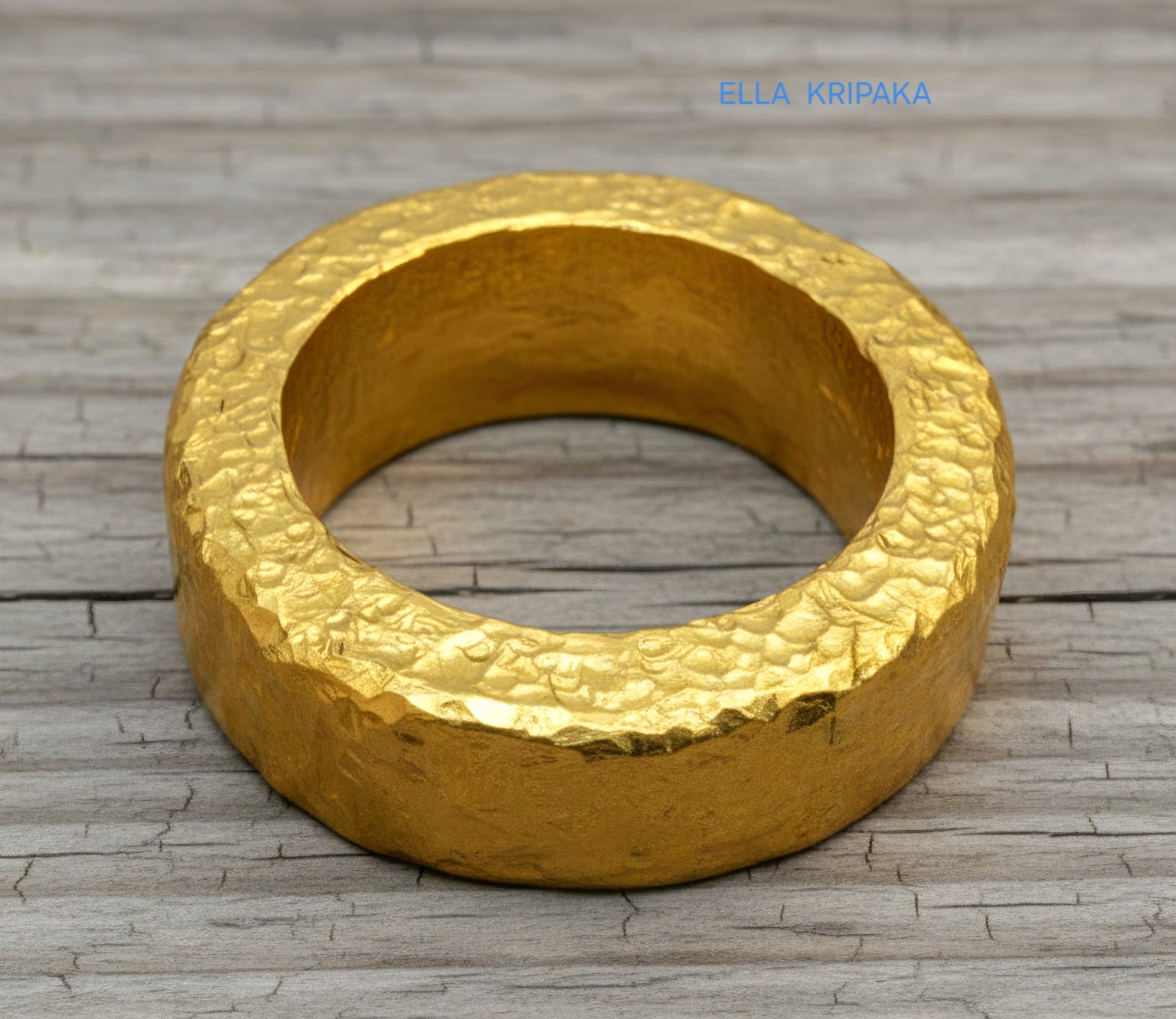Hammered 24k 9999 Gold thick ring Ancient Rome style with a textured forged gold surface on a old wooden background, branded 'Ella Kripaka'