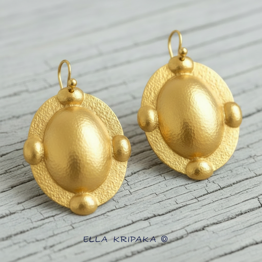 Hammered 24k gold five convex ovals earrings with shiny forged gold textures on light grey old wooden surface, artist 'Ella Kripaka' branding