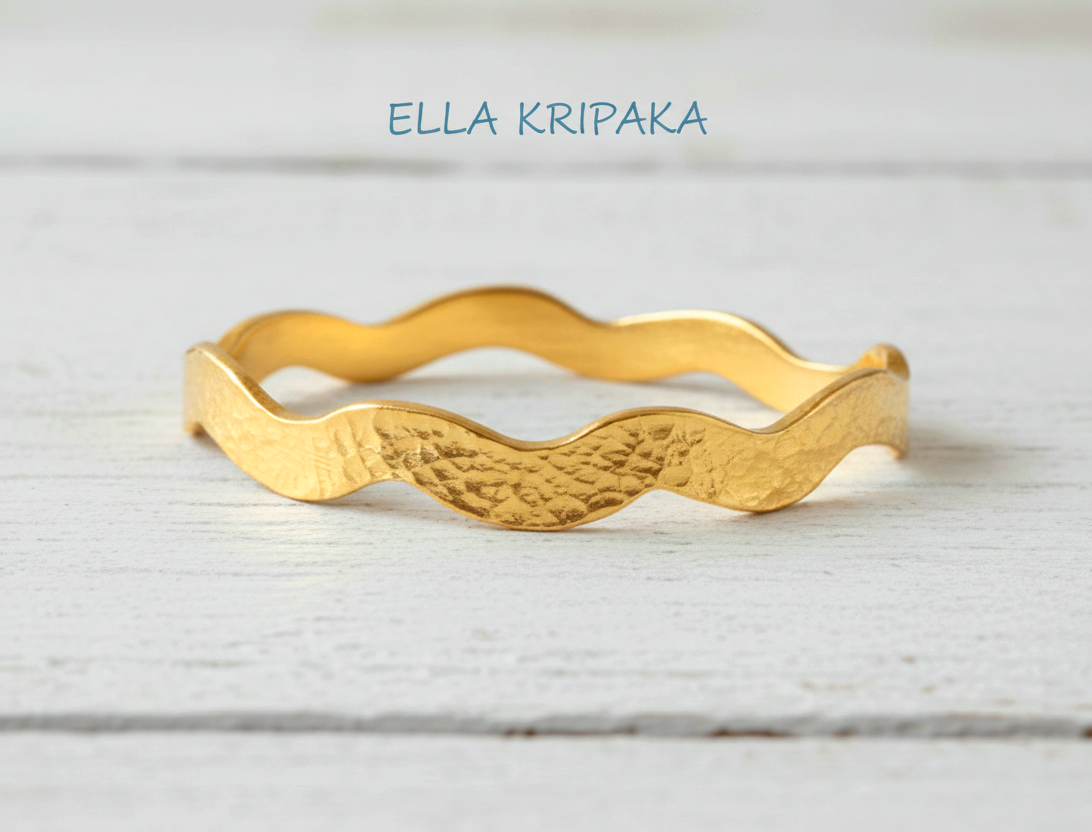 Hammered 24k 9999 Gold wavy bangle bracelet Ancient Egypt style on white wooden surface, artist's name 'Ella Kripaka' branding