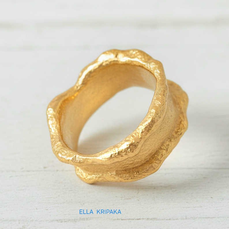 Organic 24k gold hammered ring with textured surface and uneven edges on a white craft  paper background, branded 'Ella Kripaka'