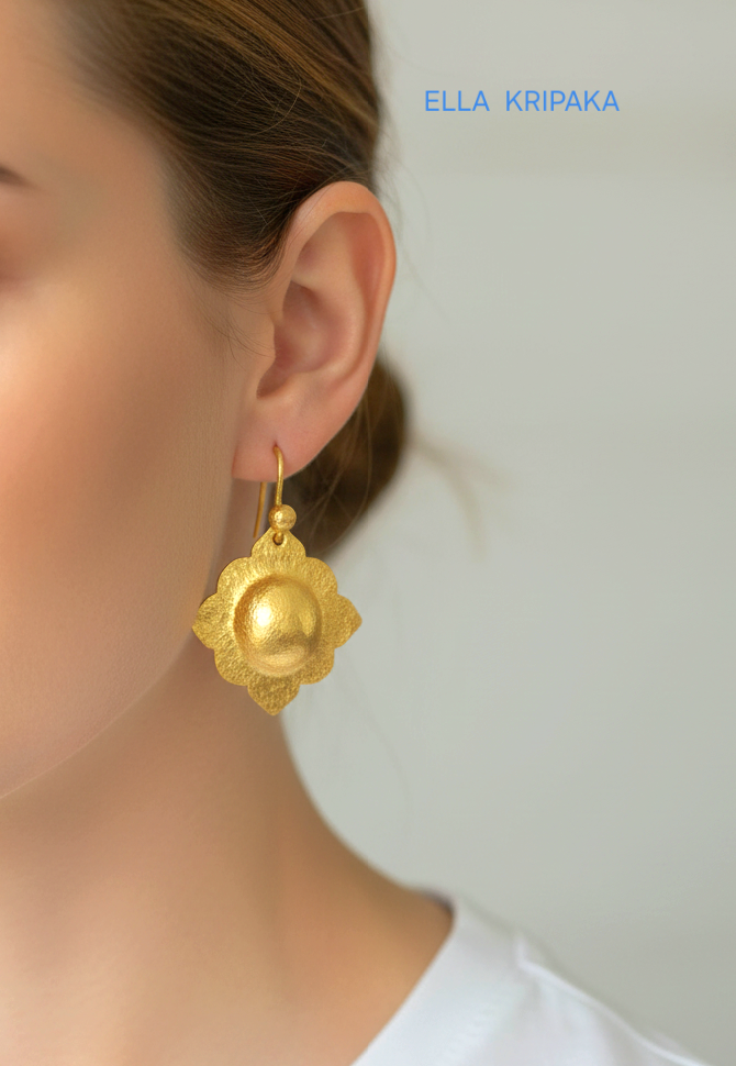 24k 9999 gold hammered Byzantine baroque convex earrings with shiny gold textures worn by a woman and on grey background, artist-jeweler's name 'Ella Kripaka'