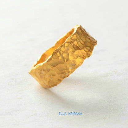 Organic hammered 24k 9999 Gold ring with uneven edges on white paper surface, artist-jeweler's name 'Ella Kripaka' is written in picture