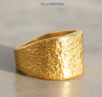 Hammered 24k Gold 9999 gold Ancient Rome  thick ring large signet with textured gold on a grey concrete background, branded 'Ella Kripaka'