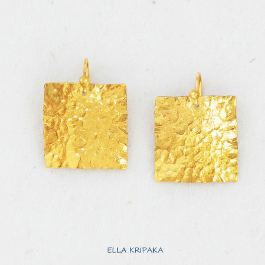 Organic 24k gold square earrings with textured reliefs on a white craft paper background with 'Ella Kripaka' branding
