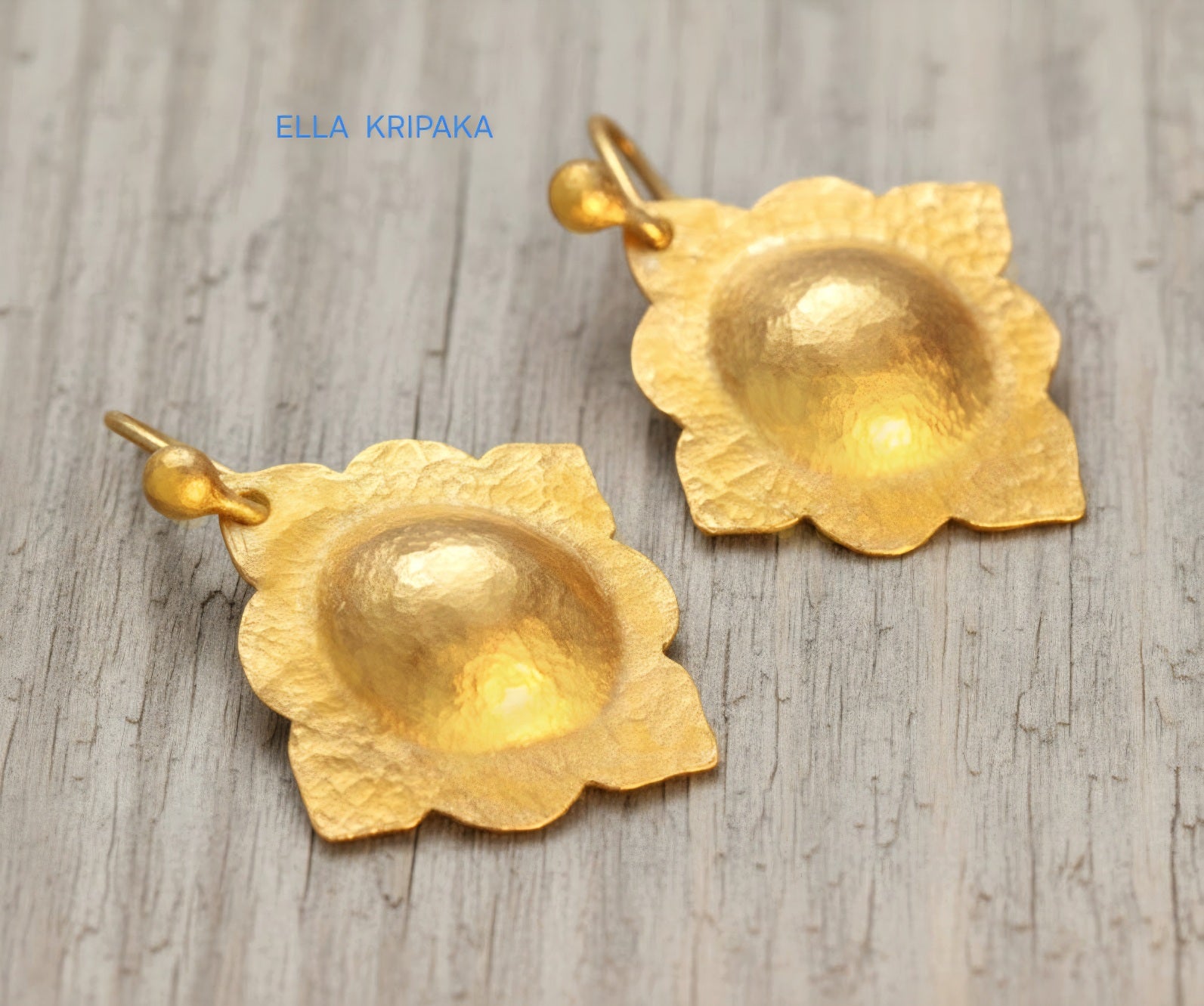 24k 9999 gold hammered Byzantine baroque convex earrings with shiny gold textures are on old wooden background, artist-jeweler's name 'Ella Kripaka'