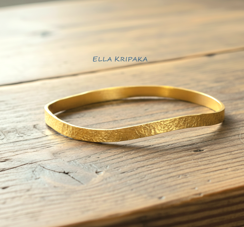 Uneven hammered 24k 9999 Gold organic bangle bracelet on old wooden surface, artist's name 'Ella Kripaka' branding