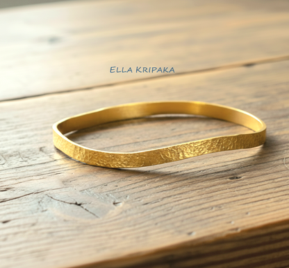 Uneven hammered 24k 9999 Gold organic bangle bracelet on old wooden surface, artist's name 'Ella Kripaka' branding