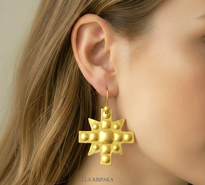 Hammered 24k 9999 Gold Byzantine cross earrings worn by a woman on a neutral background with 'Ella Kripaka' branding