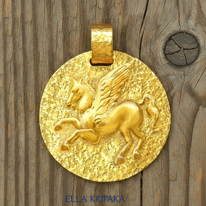 Hammered 24k Gold 9999 gold disk pendant with convex Pegasus and with textured gold on old wooden background, branded artist's name 'Ella Kripaka'