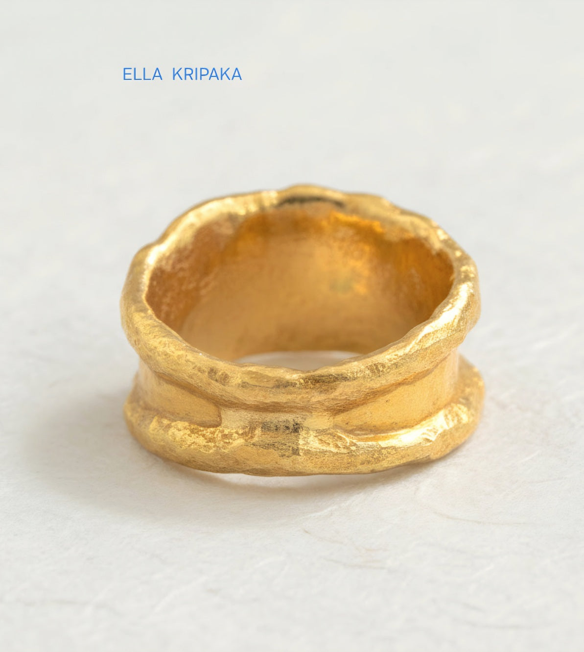 Organic hammered 24k Gold 9999 gold ring signet with thick edges and with textured surface on a white paper background, branded 'Ella Kripaka'