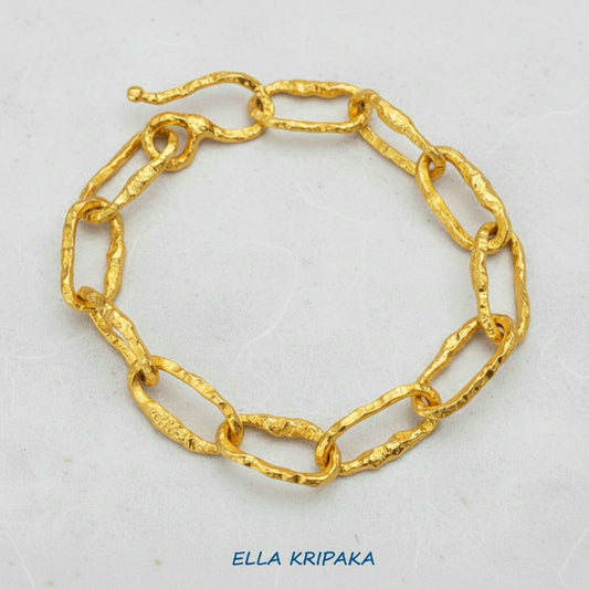Hammered 24k 9999 gold organic bracelet chain with hammered uneven textures and a thick hook clasp on white surface, artist name 'Ella Kripaka'
