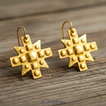 Hammered 24k 9999 Gold Byzantine cross earrings on a old wooden background with 'Ella Kripaka' branding
