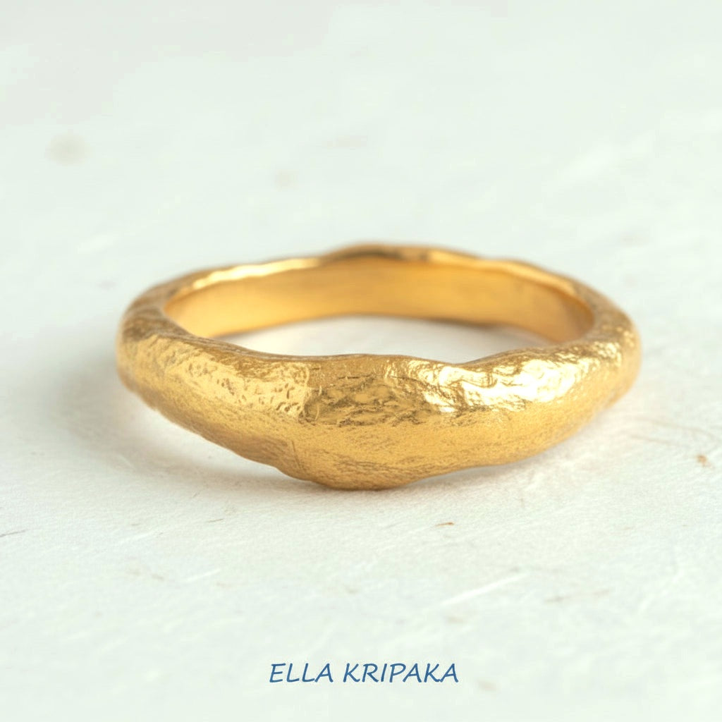 Organic hammered 24k 9999 Gold ring thick signet with uneven edges on white paper surface, artist-jeweler's name 'Ella Kripaka' is written in picture