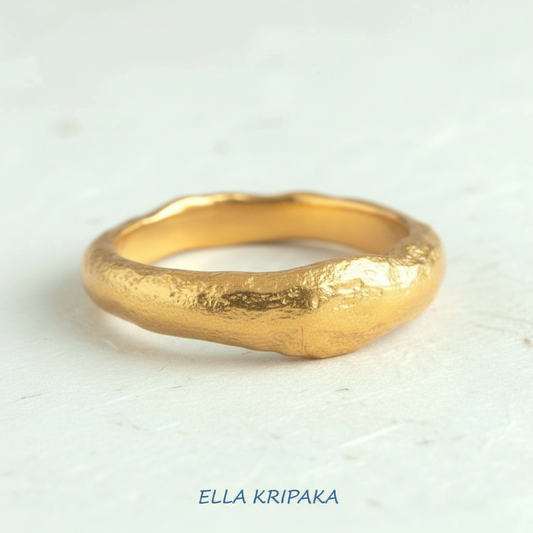 Organic hammered 24k 9999 Gold ring thick signet with uneven edges on white craft paper surface, artist-jeweler's name 'Ella Kripaka' is written in picture