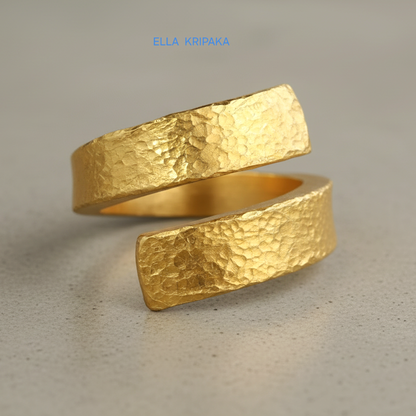 Hammered twisted 24k Gold 9999 gold signet thick ring band with textured gold on a grey concrete background, branded 'Ella Kripaka'