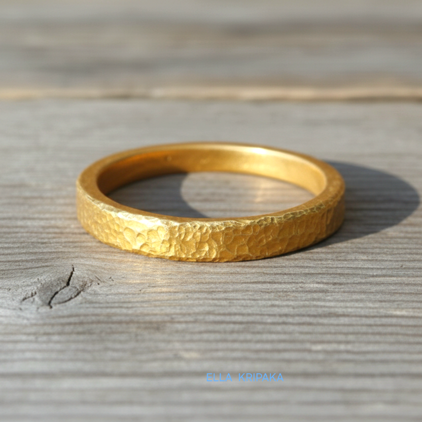 Hammered 24k gold thick ring on rustic wooden surface, artist-jeweler's name 'Ella Kripaka' is branded