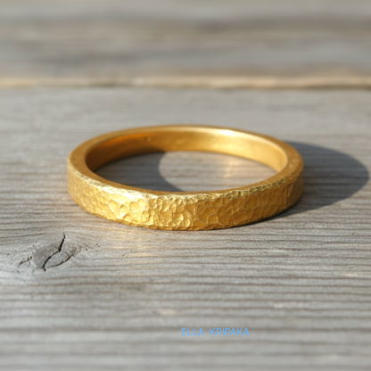 Hammered 24k gold thick ring on rustic wooden surface, artist-jeweler's name 'Ella Kripaka' is branded