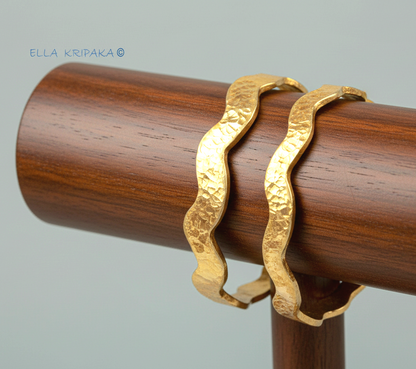 Hammered 24k 9999 Gold two wavy bangles bracelets Ancient Egypt style on wooden jewelry stand, artist's name 'Ella Kripaka' branding