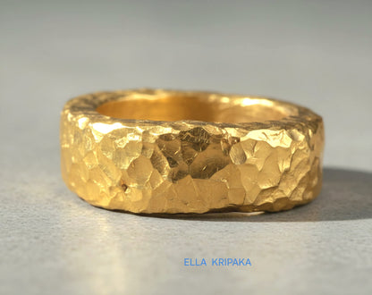 Hammered 24k 9999 Gold thick uneven ring organic with a textured gold surface on a grey concrete background, branded 'Ella Kripaka'
