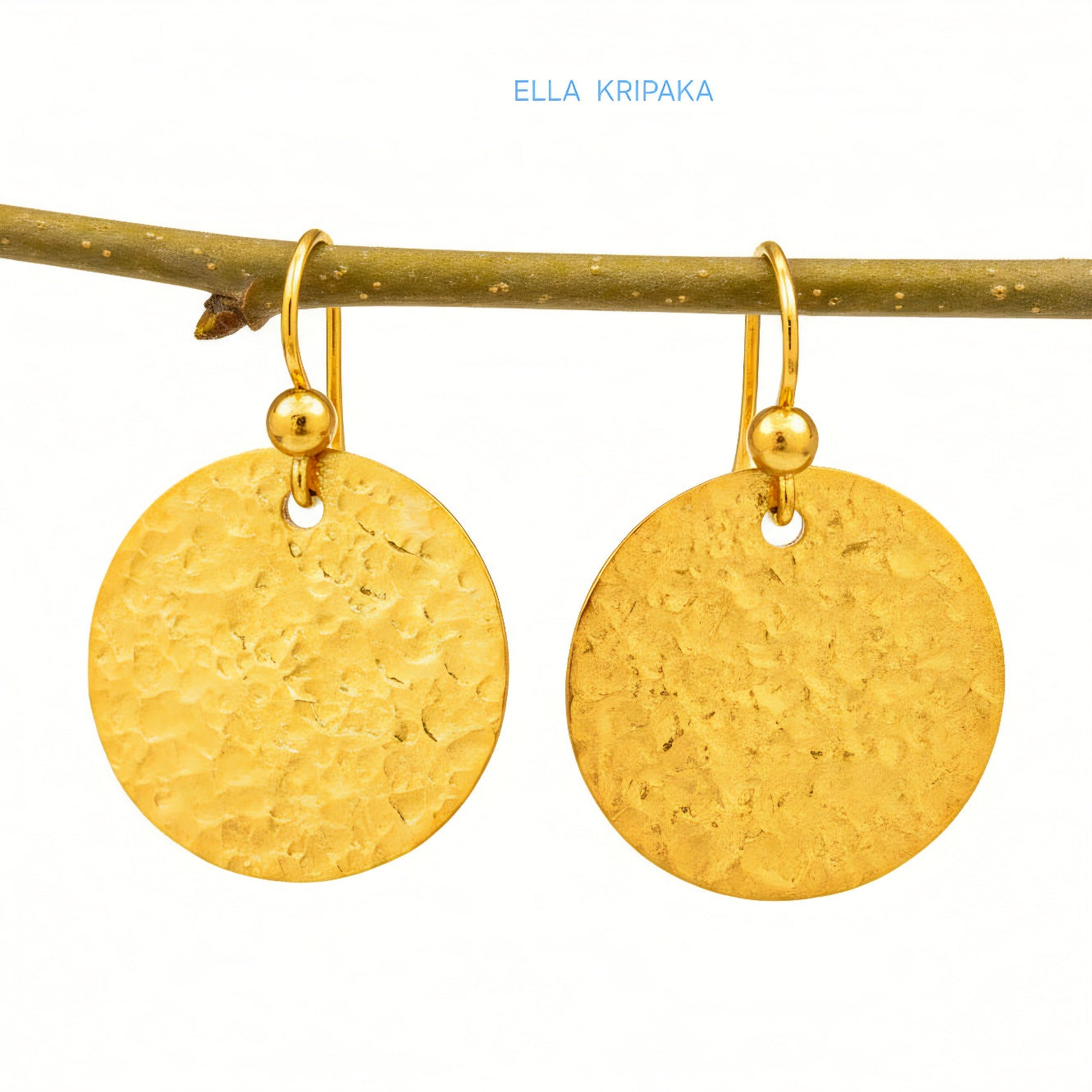 Hammered 24k gold, pure 9999 gold disk earrings with shiny forged gold textures hanging on a branch and with white  background, artist-jeweler 'Ella Kripaka' branding