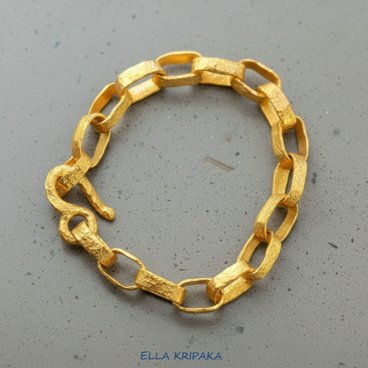 Hammered 24k 9999 gold chain thick bracelet with thick hook clasp Ancient Rome style on a grey background, artist-jeweler name 'Ella Kripaka' branding