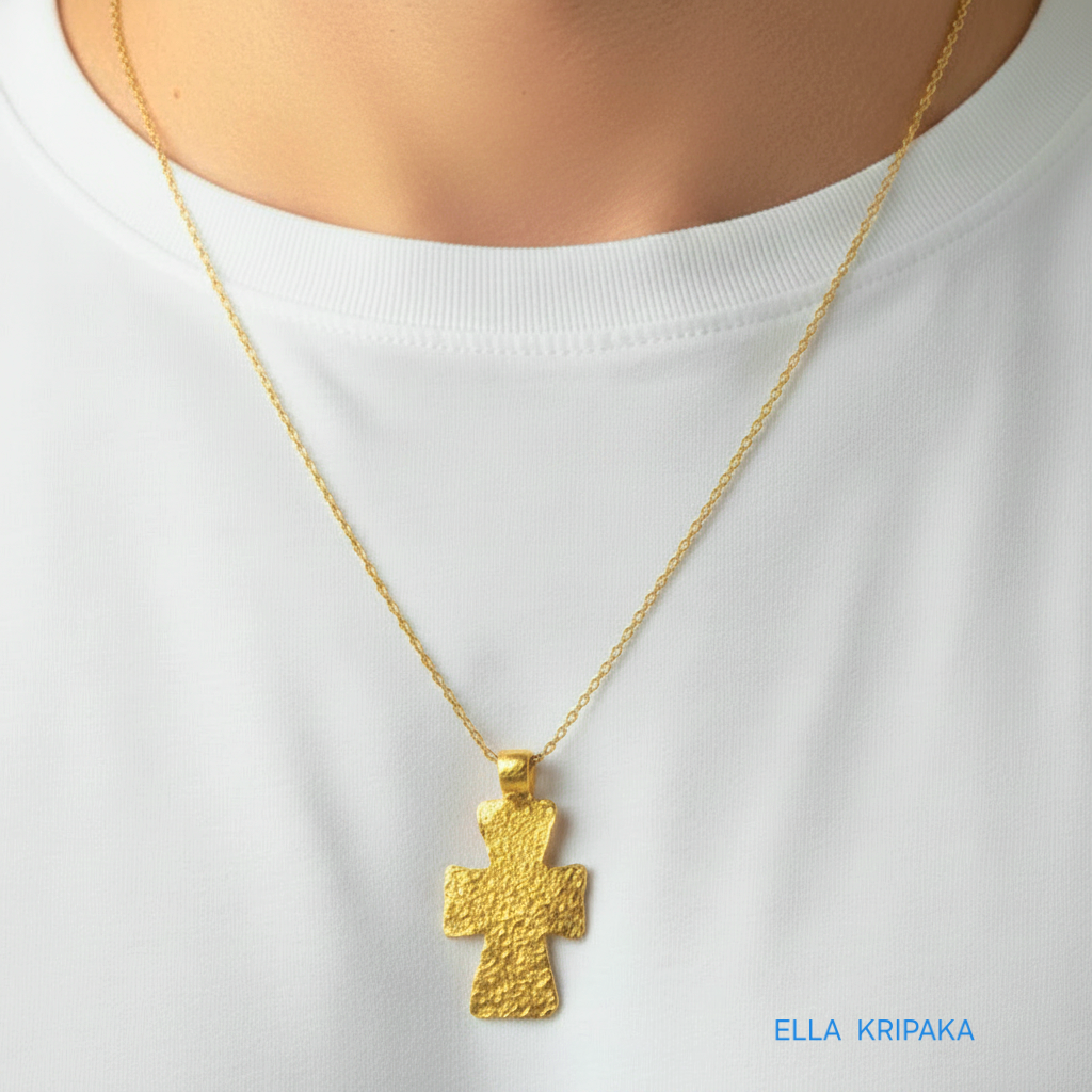 Hammered 24k gold textured cross pendant with chain worn by a person with white t-shirt, artist-jeweler 'Ella Kripaka' branding