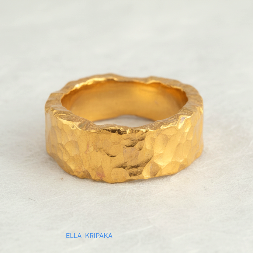 Organic hammered 24k 9999 Gold ring with uneven edges on white paper surface, artist-jeweler's name 'Ella Kripaka' is written in picture