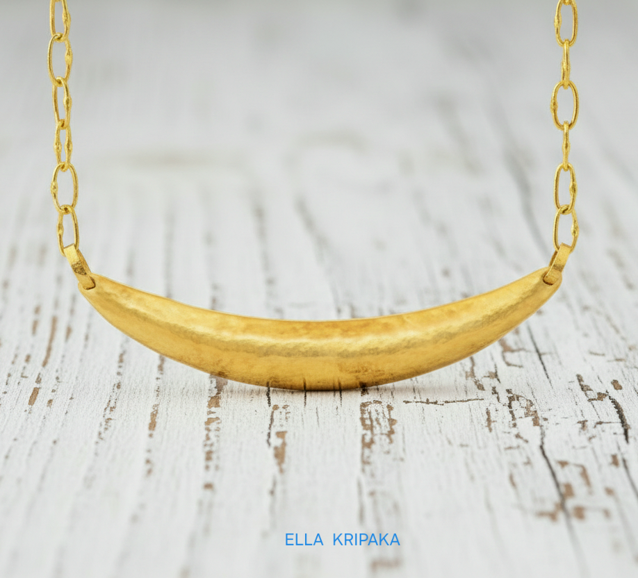 Hammered 24k gold convex Moon pendant with chain on a white rustic wooden background with 'Ella Kripaka' branding