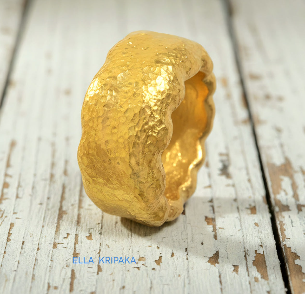 Organic hammered 24k gold 9999 Gold textured wavy thick ring on a rustic wooden surface with 'ELLA KRIPAKA' branding