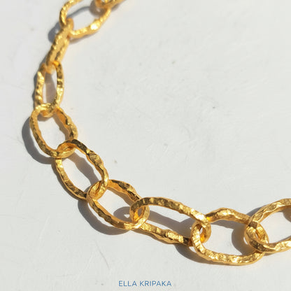 Organic 24k Gold hammered uneven textured chain necklace on a white craft paper surface, with artist 'Ella Kripaka' branding