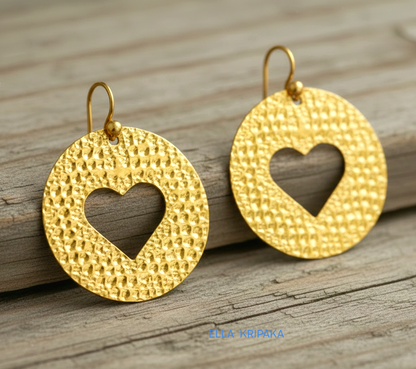 Organic 24k 9999 gold hammered heart hoops earrings with shiny gold textures and on old grey wooden background, artist-jeweler's name 'Ella Kripaka'