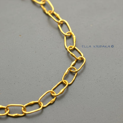 22k gold hammered chain on grey concrete background, artist-jeweler's name 'Ella Kripaka' branding