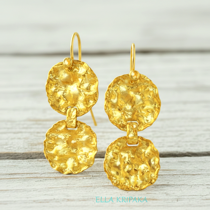Organic hammered 24k gold earrings wavy disks with uneven edges on a white old wooden surface with artist's name 'Ella Kripaka' branding