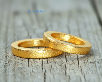 Hammered 24k Gold 9999 gold Ancient Rome  thick two rings with textured forged gold on a grey old wooden background, branded artist-jeweler's name 'Ella Kripaka'