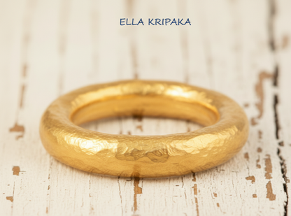 Hammered 24k 9999 Gold ring thick Ancient Rome style on old white wooden surface, artist-jeweler's name 'Ella Kripaka' branding
