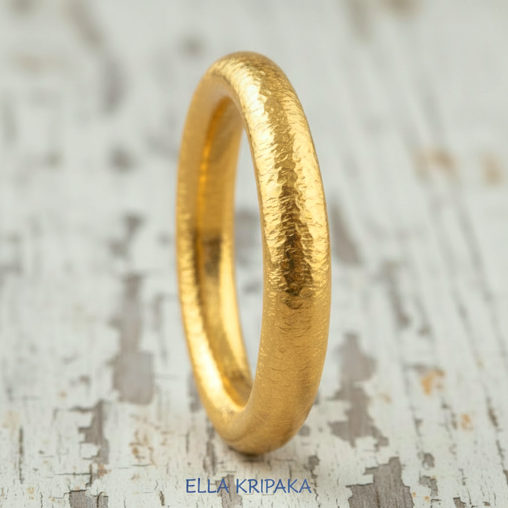 Hammered 24k gold rounded textured ring on a white old rustic wooden surface with 'Ella Kripaka' branding