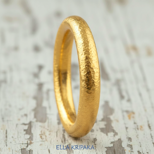 Hammered 24k gold rounded textured ring on a white old rustic wooden surface with 'Ella Kripaka' branding