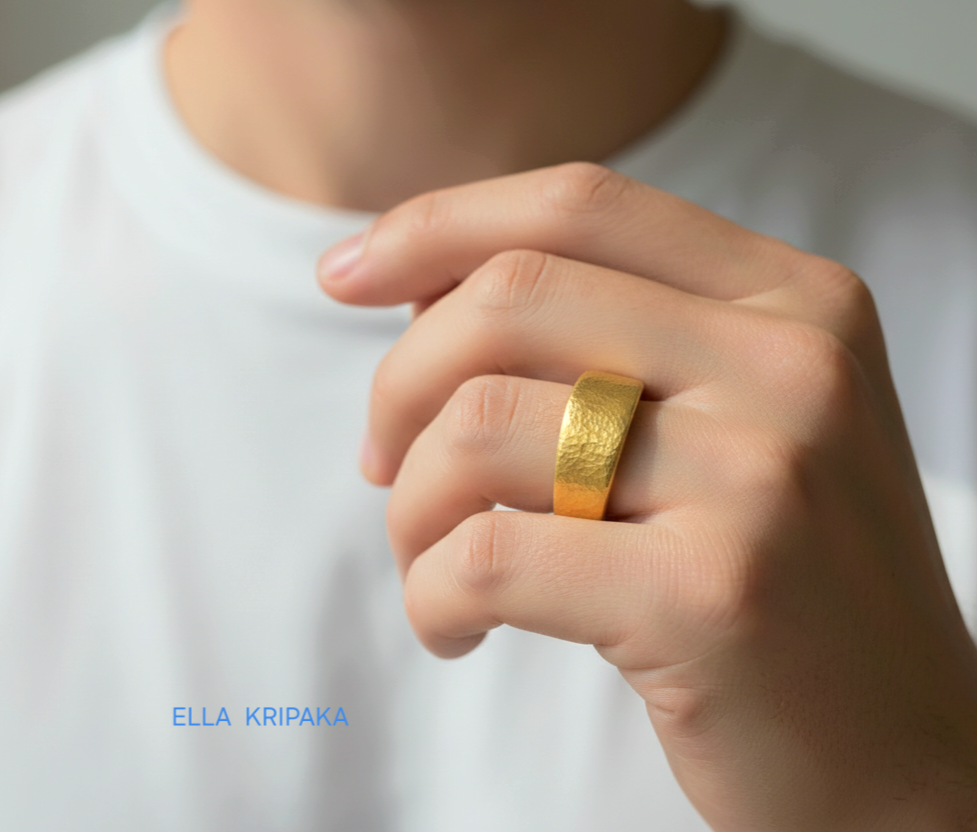 Hammered 24k Gold 9999 gold signet thick ring Ancient Rome style with textured gold worn on person's finger and on a white blurred background, branded 'Ella Kripaka'