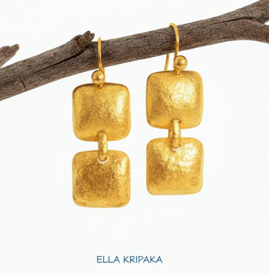 Solid 24k 9999 gold hammered Byzantine convex square earrings with hook clasps and shiny forged gold textures on old wooden background , artist's name 'ELLA KRIPAKA'