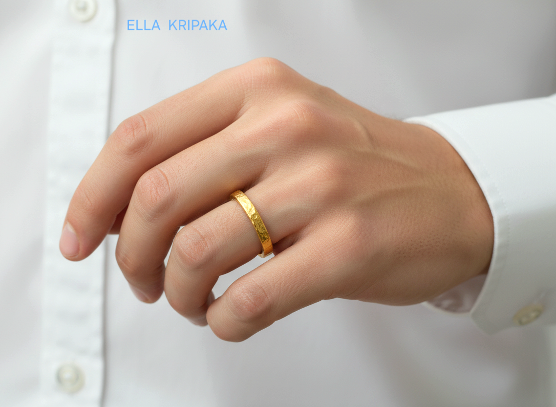 Hammered 24k gold thick ring worn by a person and on white shirt background, artist-jeweler's name 'Ella Kripaka' is branded